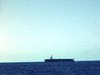Porte-avion sur la mer, puis un cargo, filmé de plus ou moins loin