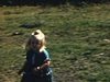 Fillette et petite fille blonde dehors devant un camion pick-up rouge. La petite court suivie par la caméra
