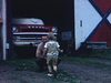 Fillette court vers son père, à la campagne devant le garage et la vieille automobile Dodge. Son père, une bière à la main, la prend dans ses bras l'embrasse - scène très québécoise