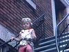 Beau plan en contre plongée d'une fillette qui descend un escalier de ville, elle circule en tricycle sur le trottoir, lunettes soleil sur la tête
