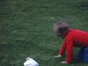 Fillette fait des culbutes dans l'herbe (acrobaties)