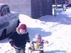 Hiver, fillette traine bébé fille dans un traineau dans la ruelle
