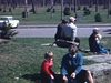 Printemps dans un parc: tout le monde assis sur des roches, ils flattent le chien tour à tour