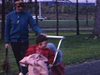 Automne: mère et ses deux fillettes. Promenade au parc. Bébé fille pousse landau où est assise la fillette - beaucoup de plaisir - jeux
