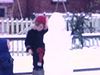 Deux fillettes fabriquent un bonhomme de neige dans la cour donnant sur la ruelle. Fillette met une tuque au bonhomme, parle à la caméra, pose des yeux, un nez une bouche: beaux plans; les deux fillettes finissent le bonhomme de neige.