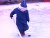 Fillette de 3 ans sur une patinoire extérieur de la ville, essaie de jouer au hockey.
