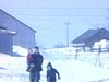 Papa et deux fillettes marchent sur le terrain enneigé de la ferme