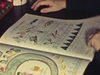 Beaux gros plans sur grand livre à colorier et de jeux d'apprentissage scolaire, dont la fillette tourne les pages- Cahier de maths - école
