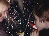 Deux fillettes embrasses les figurines de lutins de Noël accrochées dans le sapin