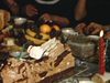 Fête de Jour de l'An. À table: bûche de Noël et les convives autour de la table qui mangent et rient (agitation pendant le repas) on ouvre quelques cadeaux