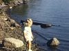 Bébé sur la plage, au bord du lac, près d'un quai de chalet. Plan au bord d'un grand lac (Lac Saint-Jean?)