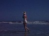 Floride - belle madame les ieds dans l'eau, saute les vagues puis elle court dans l'eau et s'amuse le long des vagues