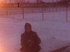 Hiver - maman assise au bord de la patinoire, met ses mitaines