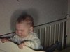 Anniversaire au sous-sol - bébé dans bassinette - son frère lui donne un pistolet (rigolo)
