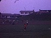 Partie de soccer d'enfants - banlieue - sur un terrain entouré de bungalows, équipes organisées - quelques beaux plans de la partie (sombre)