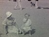 Plage (Old Orchard?) années 30 - Un bébé fait ses premiers pas dans le sable, devant sa mère. Des gens se font bronzer, des enfants courent, Baigneurs vus de loin.