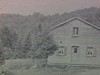 Bâtiments de ferme avec clôtures, Un homme avance vers la caméra en fumant.
