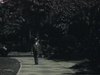Un homme bien habillé avance sur le trottoir d'un jardin (?) et salue la caméra de la main (le geste part de son chapeau), Près de la caméra il enlève son chapeau.