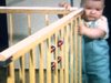 Bébé  marche en s'agrippant à son pèer puis il marche à 4 pattes: joue avec une prise électrique et un fil d'extension (danger)