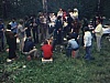 Feu de camp, pique-nique en grand nombre - hommes assis sur des caisses de bière. Guimauves, Femme avec chemise de chasse. 
