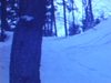 Ski-doos débouchent dans le bois vers la caméra. Glaçons sur les rochers, lac gelé. on pousse le ski-doo dans une côte, cigarette au bec - beaux plans