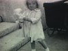 Fillette avec un caniche jouet. Garçonnet traine petite fille dans sa poussette d'osier (pousse-pousse chinois d'enfant)  Garçon avec auto en tôle, embrasse fillette, parc Murry,