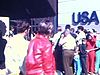 Terre des Hommes: Entrée du pavillon des États-Unis, immense file d'attente, des gens déambulent sur le site, dont deux religieuses en voile blanc.