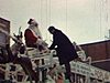 Char du père Noël: Réal Giguère grimpe sur le traineau avec son micro pour interviewer le père Noël