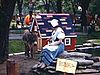 Parc Lafontaine:  phoques qui plongent, amusent les visiteurs. Personnage de conte pour enfant avec un âne, homme salue la caméra depuis un bateau au milieu du zoo
