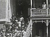 Foule nombreuse assiste à une parade. Gens sur les marches d'escaliers regardent passer le défilé