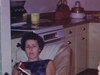 Jeune femme à la maison chez ses parents, elle lit un magazine. son père va changer une ampoule, elle fait un casse-tête à la table - 1965 - quotidien