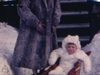 Une femme et deux petites filles sortent d’une maison à Montréal, la mère met la plus jeune dans un traineau, la plus grand tire le traineau sur la neige