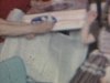 Anniversaire d’une petite fille, elle reçoit un ensemble de thé miniature, fait une ronde avec ses amies et sa mère, gonfle des balounes assise sur le divan, chapeaux, souper de famille, elle souffle les bougies sur son gâteau