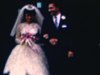 Réception mariage, invités et mariés posent sur le parvis de l’église, le marié prend la main de sa femme - beau plan 1962