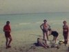 Voyage dans le sud, gens sur la plage jouent au volleyball, boivent une bière, se font bronzer