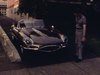 Un homme montre sa nouvelle automobile - une Jaguar, il fait un tour dans les rues d’un quartier résidentiel