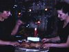 Deux femmes grapillent dans un rôti sur une table basse devant le sapin de Noël - années 50