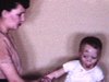 Bébé garçon tout sale, sa mère le déshabille et va le laver, il joue dans le bain, elle joue avec lui, puis lui met du talc et le rhabille - années 50