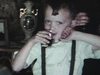 Party de famille, un garçon avec un verre d’alcool dans les mains. les gens sont assis au salon et discutent - 1954-55 