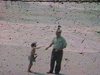 Petite fille et grand-père nourrissent des oiseaux sur la plage près des vagues