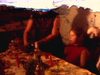Repas de famille dans la petite cuisine d’un appartement, table bien mise pour Noël, déballage de cadeaux au salon (images rouges et sombres)
