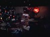 Party de famille à Noël, un homme prend des photos de sa famille assise au salon, puis il embrasse sa femme, déballage de cadeaux, les gens reçoivent beaucoup de vêtements