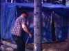 Un homme monte une tente sur son terrain de camping dans la forêt