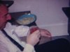 Party de famille, enfants assis sur le divan montrent des cartes qu’ils ont faites, ils dansent, les adultes boivent et mangent des chips sur la table bien mise - Noël