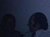 Party de famille à la cuisine, images sombres, les gens s’embrassent, rient, un couple de fiancés montre la bague de fiançailles