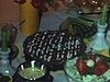Buffet pour un party de famille, crudités, viandes froides, saumon. Une femme coupe un gâteau et on voit une file d’invités qui attendent pour être servis