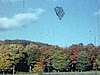 Automne, paysage d’arbres colorés - Laurentides - des marcheurs sur la route traversant la forêt, un homme tient une petite fille dans ses bras - paysages colorés - Laurentides