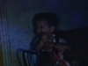 Deux enfants à la maison (sombres) petite fille met un chapeau à un petit garçon, ils jouent et se passent le chapeau