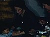 Famille mange au salon, réception après le baptême, une mère prend sa petite fille sur ses genoux et lui fait manger du gâteau - chic, nourriture