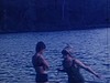 Femme en maillot de bain sort de l’eau, elle va rejoindre un garçon au bord de l’eau, trois filles sautent à l’eau et s’amusent sur une plate-forme flottante, elles nagent et s’amusent